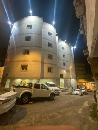 um camião estacionado em frente a um edifício à noite em فندق1 em Az Zahrāʼ