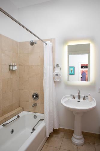 a bathroom with a tub and a sink and a bath tub at Paradise Inn - Adult Exclusive in Key West