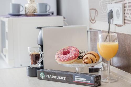 two donuts on a plate next to a glass of orange juice at Grand Budapest Penthouse in Budapest