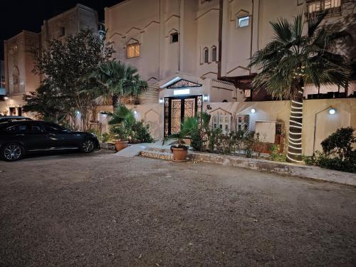 Khair Jewaar Apartments Al Madinah في المدينة المنورة: سيارة متوقفة أمام مبنى في الليل