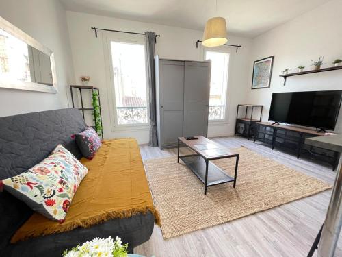 un salon avec un canapé et une télévision à écran plat dans l'établissement Little Good time, à Marseille