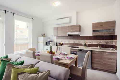 a kitchen and living room with a table and a couch at Grand Budapest Penthouse in Budapest