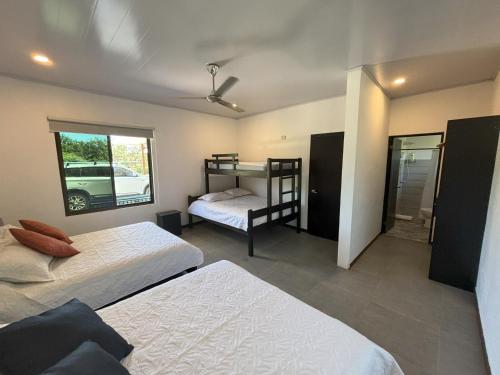 Amazilia Guesthouse في ليبيريا: غرفة نوم بسريرين وسرير بطابقين