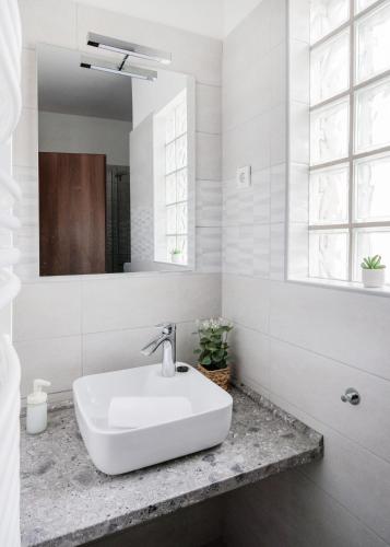a white bathroom with a sink and a mirror at Grand Budapest Penthouse in Budapest