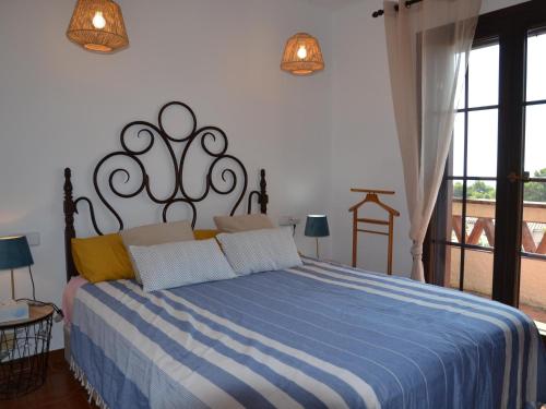 Schlafzimmer mit einem Bett mit einer blauen und weißen Bettdecke in der Unterkunft Casa L'Estartit, 2 dormitorios, 4 personas - ES-323-30 in L'Estartit