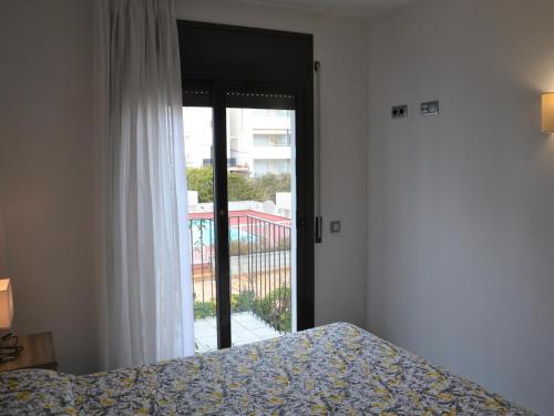 ein Schlafzimmer mit einem Bett und einer Tür zu einem Balkon in der Unterkunft Apartamento céntrico con piscina, parking y a 200m de la playa en L'Estartit - ES-323-41 in L'Estartit