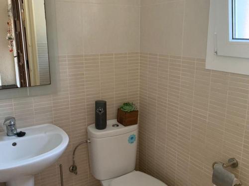 ein Badezimmer mit einer weißen Toilette und einem Waschbecken in der Unterkunft Casa bien cuidada con piscina comunitaria, terrazas y cerca de la playa en L'Estartit - ES-323-42 in L'Estartit