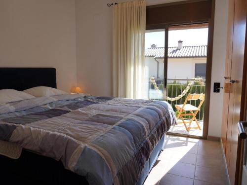 ein Schlafzimmer mit einem Bett und einer Glasschiebetür in der Unterkunft Casa moderna con piscina comunitaria, cerca de L'Estartit y actividades en la playa - ES-323-51 in L'Estartit