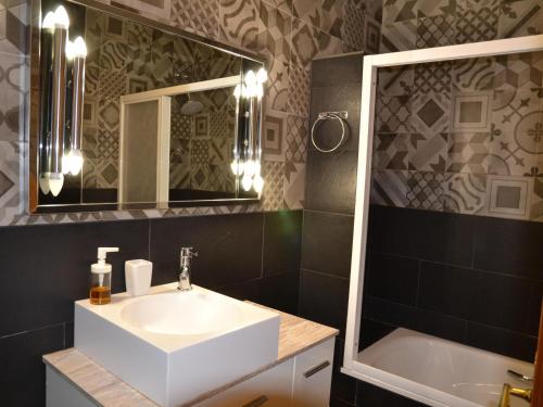 ein Badezimmer mit Waschbecken, Spiegel und Badewanne in der Unterkunft Casa Carmen - L'Estartit, Torre Vella - ES-323-67 in L'Estartit