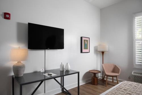 a living room with a tv on a white wall at Paradise Inn - Adult Exclusive in Key West