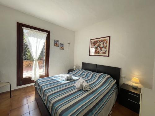 1 dormitorio con 1 cama con 2 toallas en Punta Est Giardino e Vista Mare, en Capo Coda Cavallo