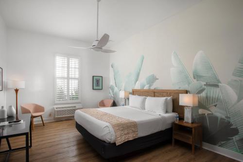 a bedroom with a king sized bed and a desk at Paradise Inn - Adult Exclusive in Key West