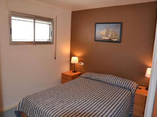 ein kleines Schlafzimmer mit einem Bett und einem Fenster in der Unterkunft Apartamento L'Estartit, 2 dormitorios, 4 personas - ES-323-36 in L'Estartit