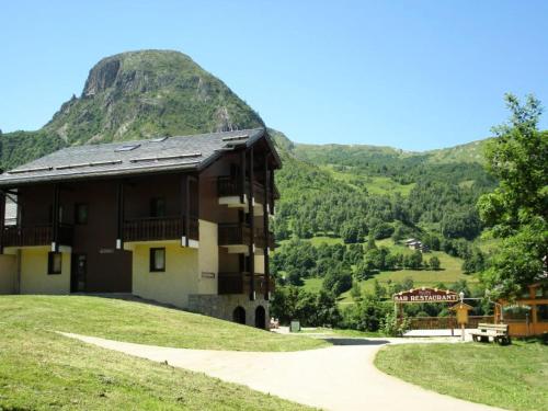 a building on a hill with a mountain in the background at Résidence Gentianessmb - 2 Pièces pour 4 Personnes 964 in Saint-Martin-de-Belleville