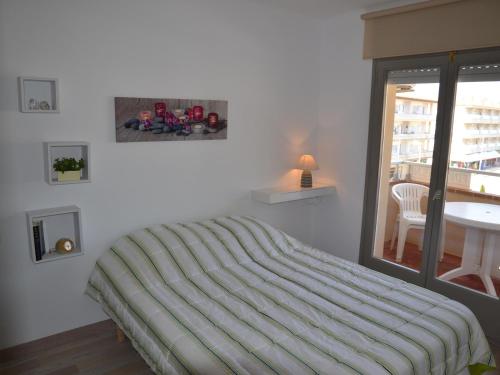 - une chambre avec un lit et une couverture rayée dans l'établissement Apartamento L'Estartit, 2 dormitorios, 4 personas - ES-323-50, à L'Estartit