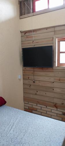 a bedroom with a flat screen tv on a wall at Morada Sol e Lua Container Guarda do Embaú com Ar condicionado in Guarda do Embaú
