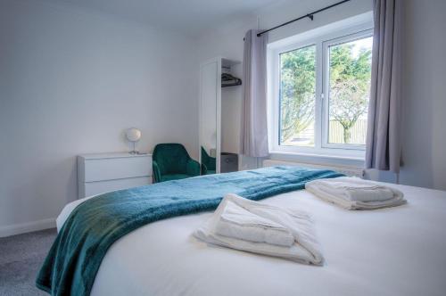 - une chambre avec un lit et des serviettes dans l'établissement Gower Hideaway - 3 Bed Apartment - Ocean Breeze, à Port Eynon