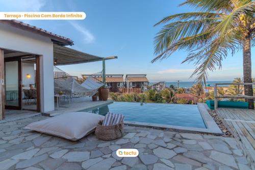 uma villa com uma piscina e uma palmeira em Casa Desert Point com piscina vista mar por Tactu em Taíba