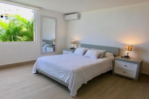 um quarto com uma cama e uma grande janela em Beach front apartment at emotions em San Felipe de Puerto Plata