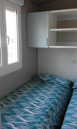 a small room with a bed and a window at Campeggio Piano Grande in Baveno