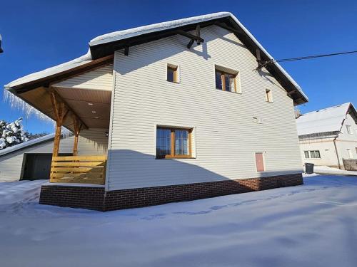 a house with a gambrel roof on a snow covered yard at Apartmán Buky 2 s krytou terasou a grillem in Mladé Buky