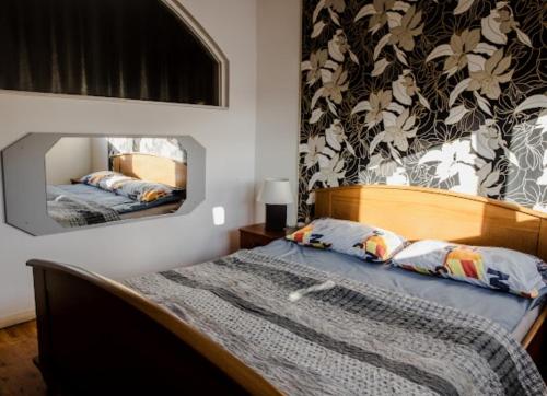 een slaapkamer met een bed met een spiegel aan de muur bij Widok Rynek Pokoje &Parking in Kielce