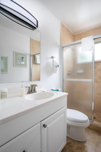a white bathroom with a sink and a toilet at Paradise Inn - Adult Exclusive in Key West