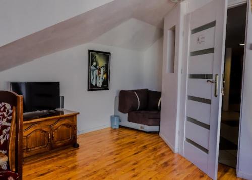 a living room with a television and a couch at Hotels-Widok Rynek - Centrum &Parking -fak VAT in Kielce