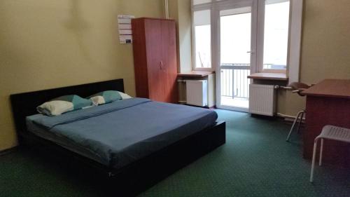 Schlafzimmer mit einem Bett, einem Schreibtisch und Fenstern in der Unterkunft Stay cool in Warschau