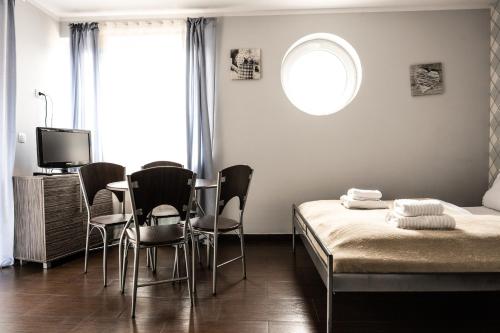 シフィノウイシチェにあるVilla Pasjaのベッドルーム1室(ベッド1台、テーブル、椅子付)