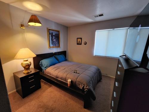 a bedroom with a bed and a lamp and a window at Buckboard House in Rio Rancho