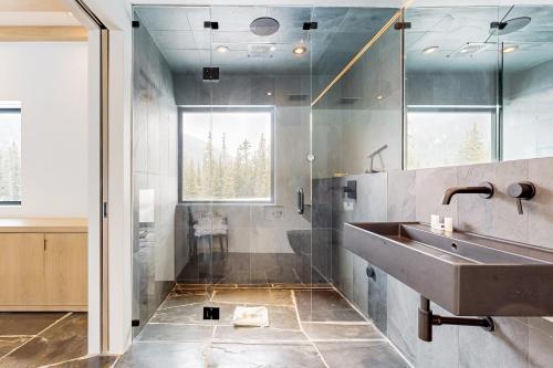 uma casa de banho com um lavatório e um chuveiro em The Waterfall House em Keystone