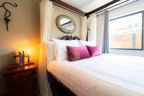 a bedroom with a bed with pink pillows and a window at Blasket View - 5 Star in Dingle