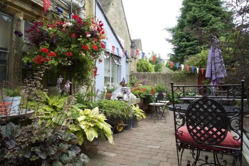 a patio with a bunch of flowers and plants at Badgers Hall in Chipping Campden