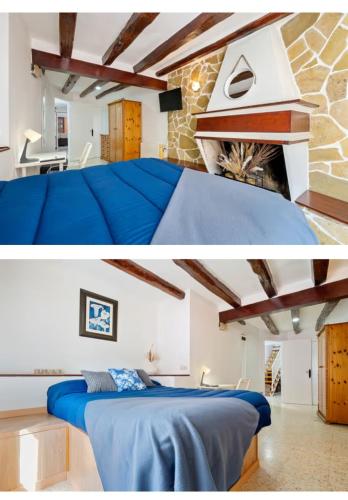 a bedroom with a blue bed and a stone wall at Ca la Neus in Marçà