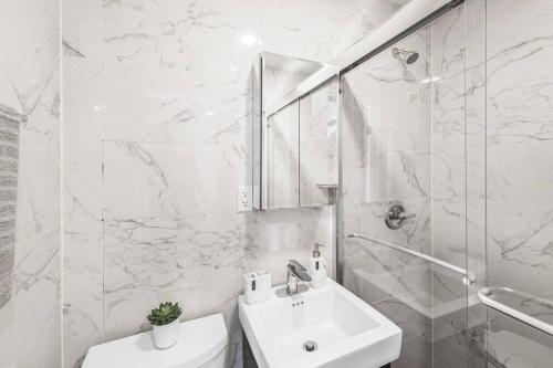 een witte badkamer met een wastafel en een toilet bij 69-5B I Stylish Lower East Side 1BR Apt BRAND NEW in New York