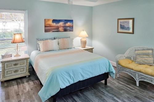 a bedroom with a bed and a chair and a window at Away from it All Abode in Sanibel
