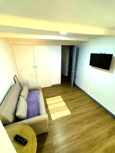 a living room with a couch and a flat screen tv at Casita de Campo en Pirque in Pirque
