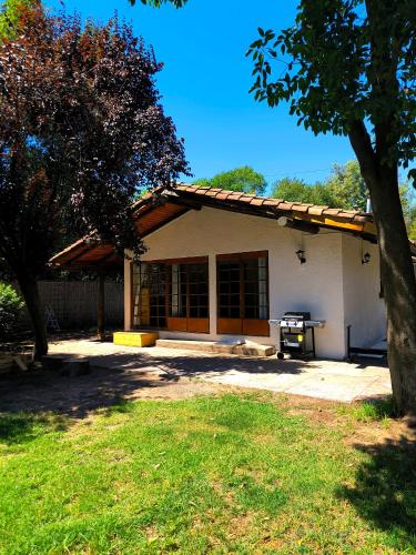 a small white house with a table in front of it at Casita de Campo en Pirque in Pirque