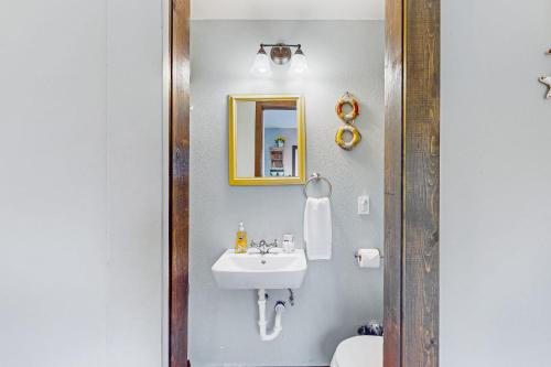 y baño con lavabo y espejo. en Breakwater Inn - Bulfinch Condo #5 en Grayland