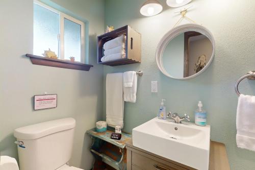 y baño con lavabo, aseo y espejo. en Breakwater Inn - Luark Condo #8 en Grayland