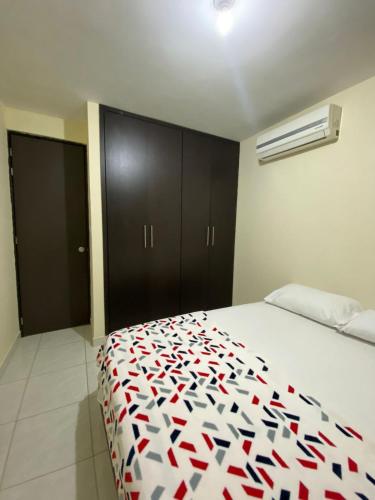 a bedroom with a bed with an apple pattern on it at Apartamento de Lujo Conjunto Marsella Real in Valledupar