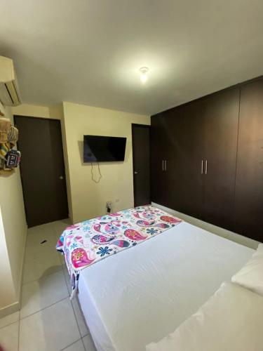 a bedroom with a large bed with a blanket on it at Apartamento de Lujo Conjunto Marsella Real in Valledupar