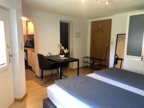 a bedroom with a bed and a table and a kitchen at Charmante, ruhige Wohnung in Innsbruck in Innsbruck