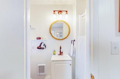 Baño blanco con lavabo y espejo en Breakwater Inn - Cranberry Cottage #A, en Grayland