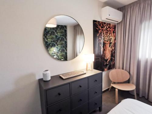 a bedroom with a dresser and a mirror at Iguazu 210 Stylish Home By Pride Holiday Rentals in Maspalomas