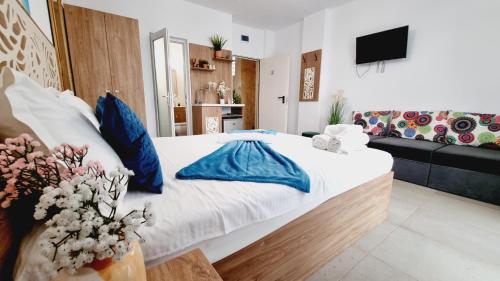 a bedroom with a large bed with blue pillows at KYD VILA - Studiouri si Apartamente la 100m de Plaja Debarcader in Eforie Nord