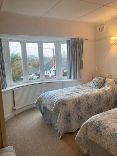 a bedroom with two beds and a window at Mariners Corner in Bexhill