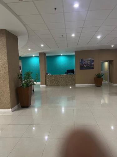 an empty lobby with blue walls and plants in a building at Cozy Beachfront View in Portmore