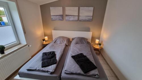 a bed in a room with two pillows on it at Ferienhaus-Nordstern in Bensersiel